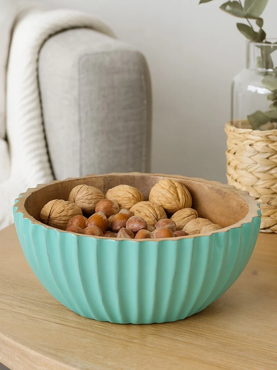 Cuenco de madera turquesa con nueces y avellanas